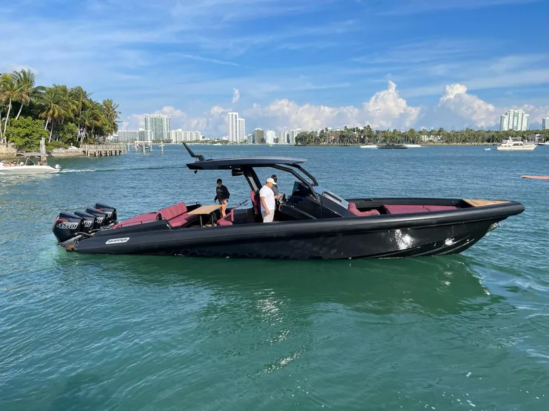 Slide: The Image of 2023 Skipper-BSK 42 boat cruising on clear blue water, with city skyline in background. - 18