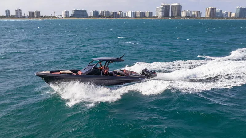 Slide: The Image of Skipper-BSK 42 boat cruising on ocean near city skyline, 2023 model. - 2