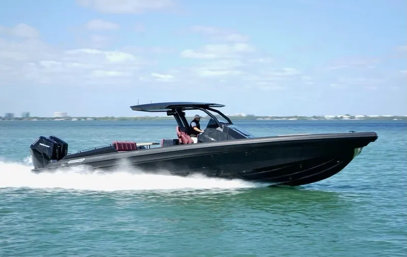 Slide: The Image of Skipper-BSK 42 boat cruising on water, 2023 model, sleek black design. - 8