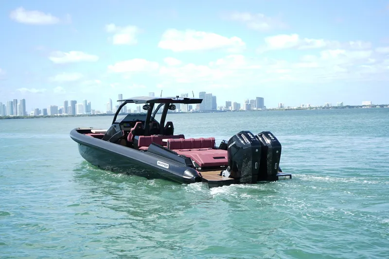 Slide: The Image of 2023 Skipper-BSK 42 boat cruising on water with city skyline in background. - 4