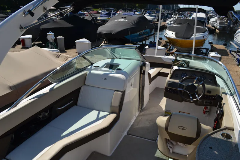 Slide: The Image of 2013 Regal 24 FasDeck boat interior with seating and steering wheel at marina. - 13