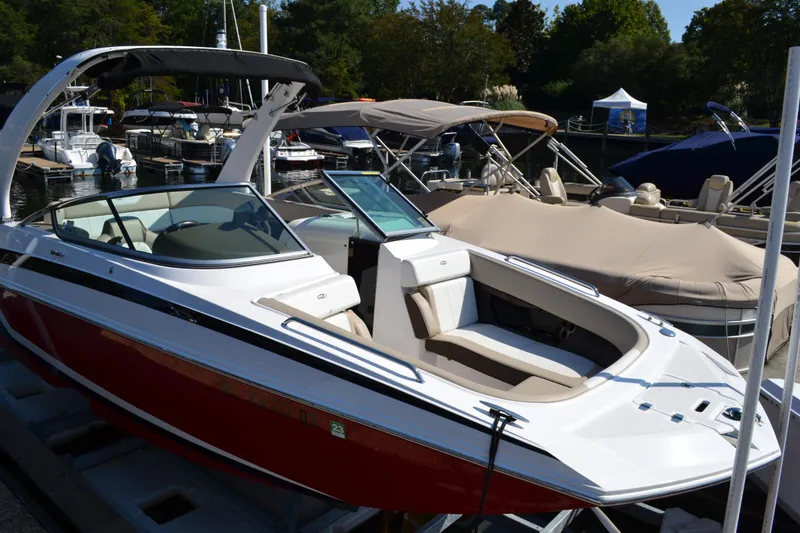 Slide: The Image of 2013 Regal 24 FasDeck boat docked, featuring sleek design and spacious seating. - 3