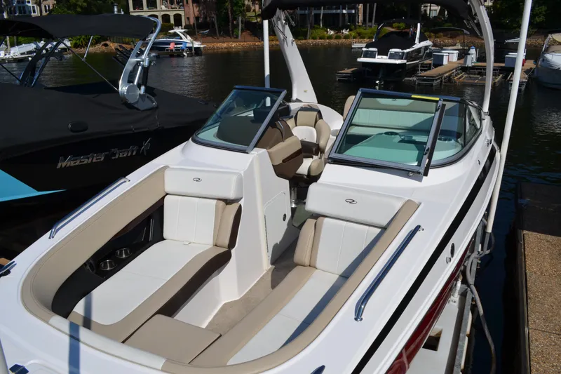 Slide: The Image of 2013 Regal 24 FasDeck boat with spacious seating docked by the water. - 8
