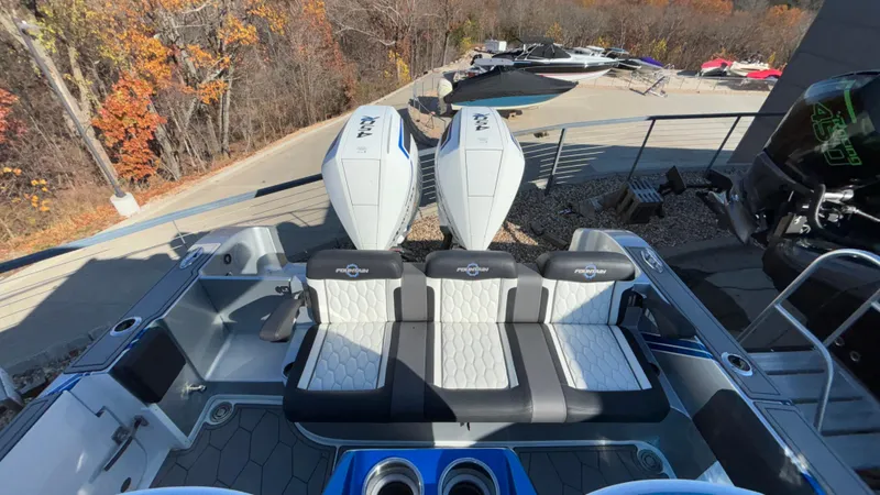 Slide: The Image of 2021 Fountain 34 SC boat with dual engines and sleek seating, docked near autumn trees. - 12