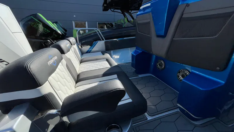 Slide: The Image of 2021 Fountain 34 SC boat interior with black and white seating and blue accents. - 14
