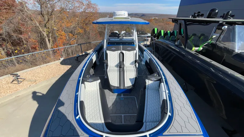 Slide: The Image of 2021 Fountain 34 SC boat with blue accents, docked outdoors. - 22