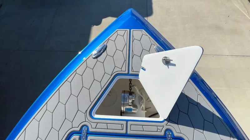 Slide: The Image of 2021 Fountain 34 SC boat bow with open anchor hatch, blue and gray design. - 25