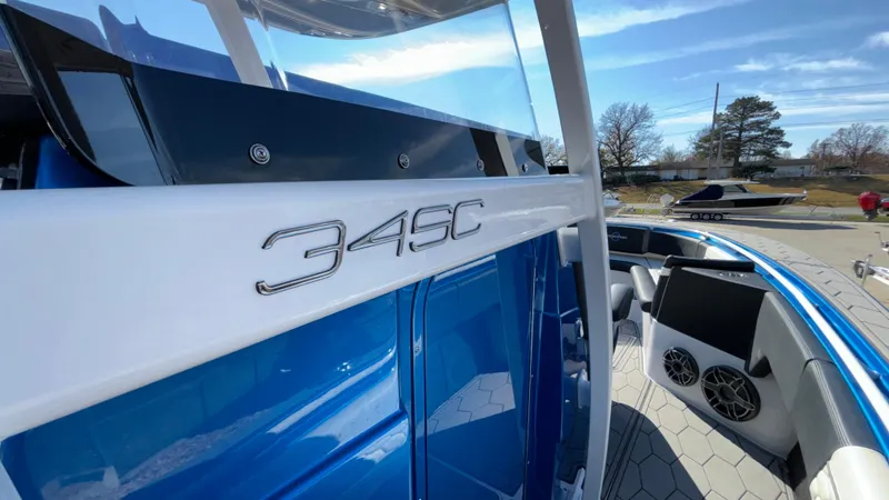Slide: The Image of 2021 Fountain 34 SC boat, blue and white exterior, sleek design, outdoor setting. - 35