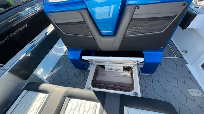 Slide: The Image of 2021 Fountain 34 SC boat interior with open storage compartment, blue and black seating. - 37
