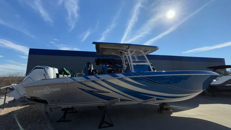 Slide: The Image of 2021 Fountain 34 SC boat with sleek blue design under a clear sky. - 4