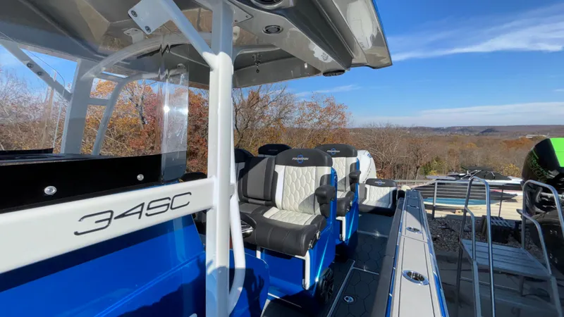 Slide: The Image of 2021 Fountain 34 SC boat interior with seating, blue accents, and scenic background. - 42