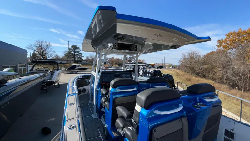Slide: The Image of 2021 Fountain 34 SC boat with blue seating and canopy, docked outdoors. - 43