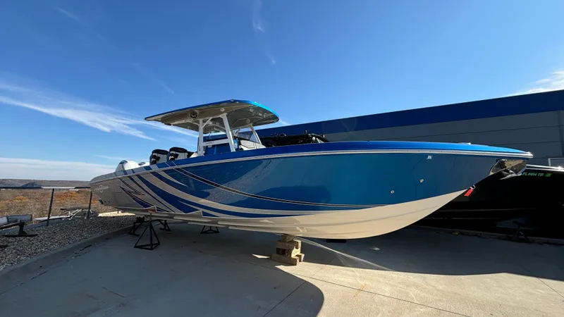 Slide: The Image of 2021 Fountain 34 SC boat with blue and white design, displayed outdoors. - 45