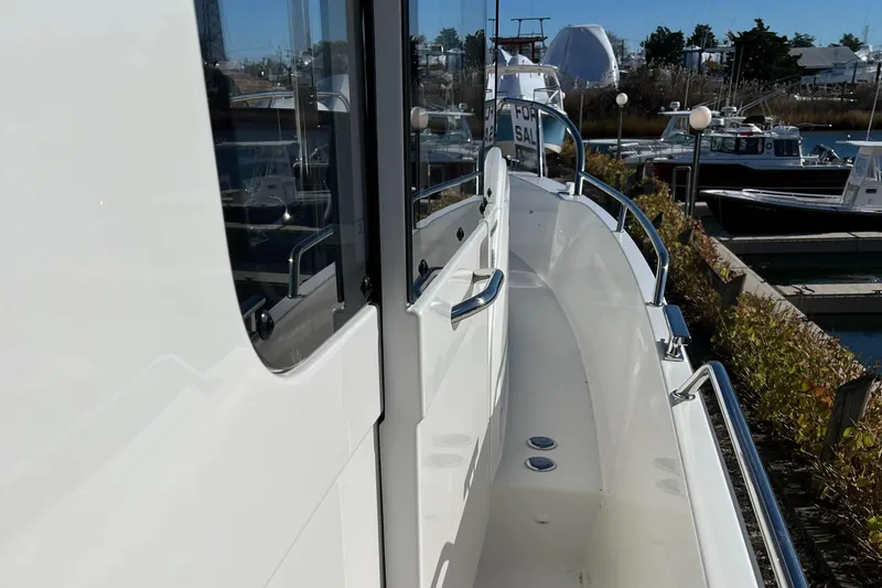 Slide: The Image of 2024 Nimbus C9 boat side view at marina, showcasing sleek design and railing. - 1