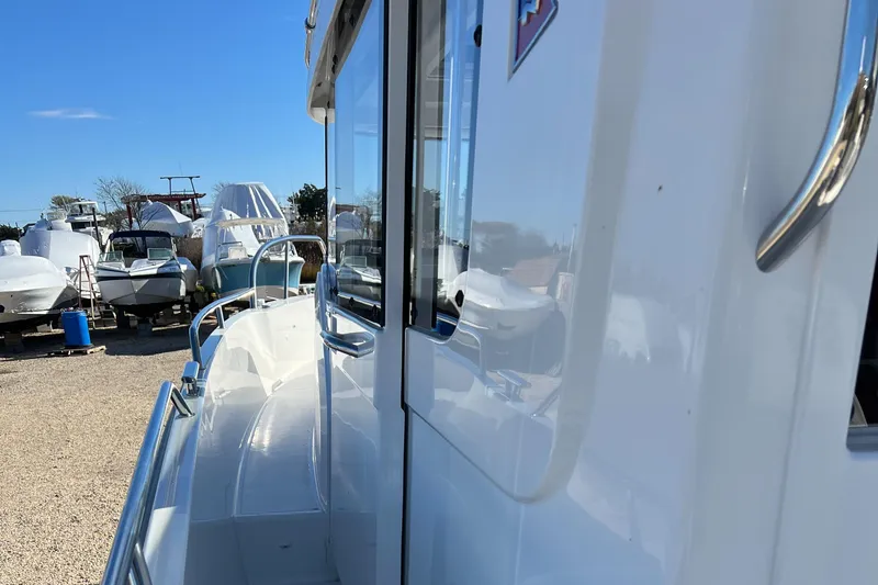 Slide: The Image of 2024 Nimbus C9 boat side view in a marina with other boats. - 2