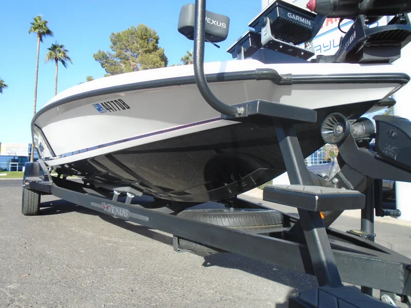 Slide: The Image of 2022 Vexus VX21 boat on trailer, parked outdoors, under clear sky. - 19