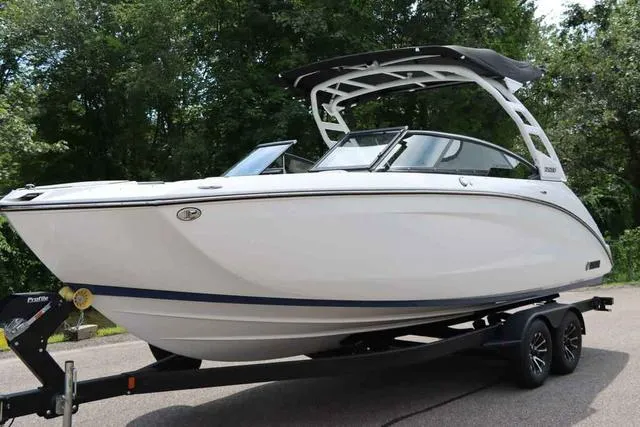 Slide: The Image of 2024 Yamaha Boats 252SD on trailer, sleek white design, parked outdoors. - 4