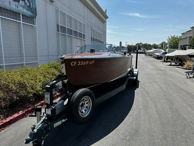 Slide: The Image of 1994 Hacker-Craft 26' Runabout on trailer, parked outdoors near industrial building. - 3
