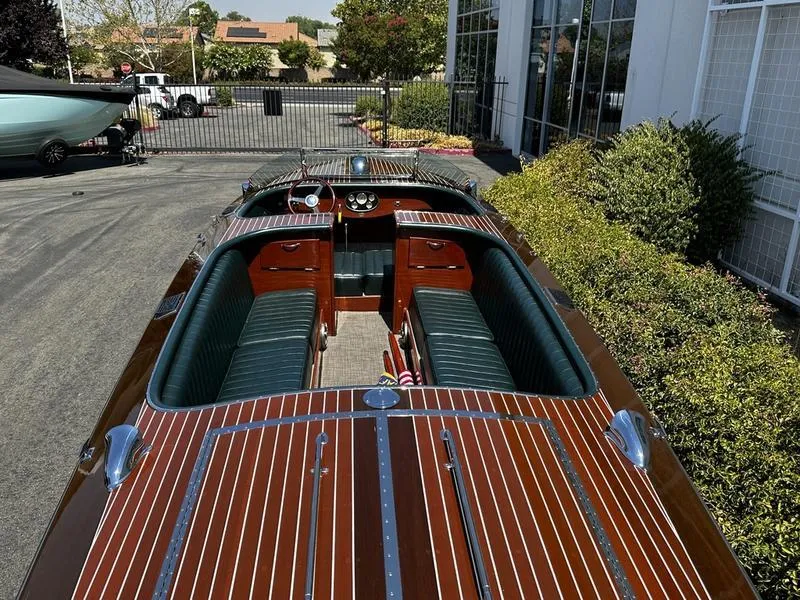 Slide: The Image of 1994 Hacker-Craft 26' Runabout with polished wood finish and green interior, parked outdoors. - 7