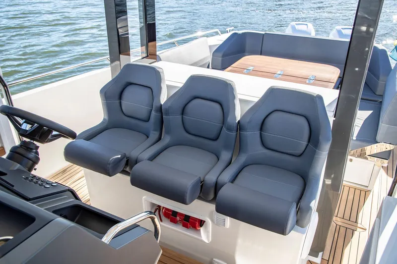 Slide: The Image of 2024 Nimbus Tender 11 boat interior with three sleek, modern seats and wooden deck. - 19