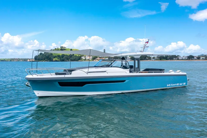 Slide: The Image of 2024 Nimbus Tender 11 boat on calm water under a clear blue sky. - 3