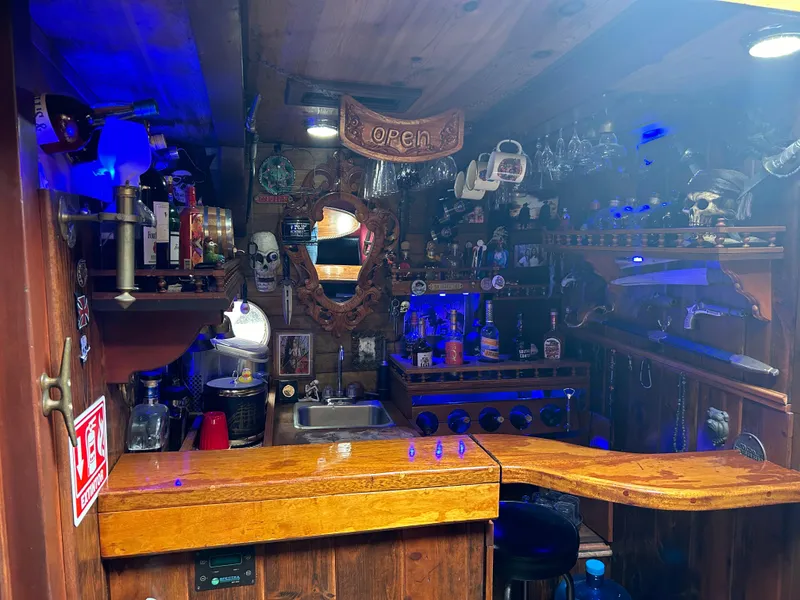 Slide: The Image of Rustic pirate ship bar interior with wooden decor, blue lighting, and nautical-themed accessories. - 3