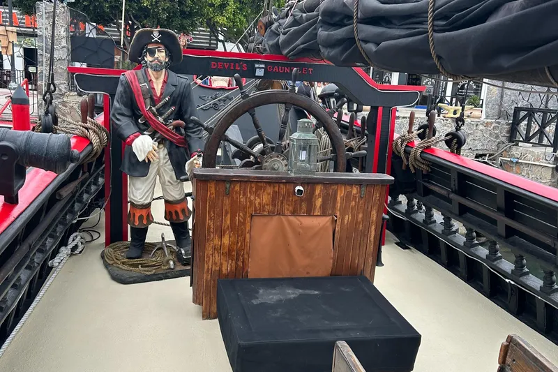 Slide: The Image of Pirate-themed ship deck with steering wheel and pirate statue, 2019 Devils Gauntlet model. - 4