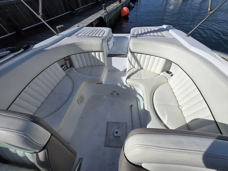 Slide: The Image of 2006 Cobalt 262 boat interior with white leather seating and dockside view. - 20