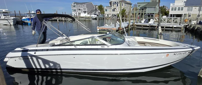 Slide: The Image of 2006 Cobalt 262 boat docked in a marina with waterfront homes in the background. - 21