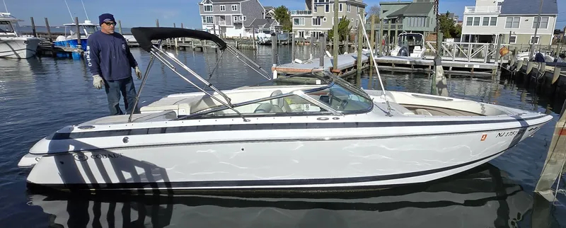 Slide: The Image of 2006 Cobalt 262 boat docked in a marina with waterfront houses in the background. - 22