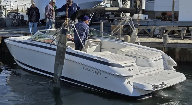 Slide: The Image of 2006 Cobalt 262 boat docked with people onboard, featuring sleek white design. - 25