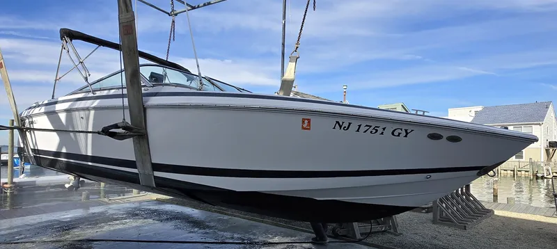 Slide: The Image of 2006 Cobalt 262 boat suspended on a lift, displaying registration NJ 1751 GY. - 27