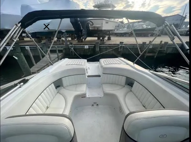 Slide: The Image of 2006 Cobalt 262 boat with white seating and black canopy at a marina. - 4