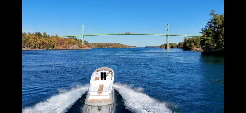 Slide: The Image of 2024 Comitti Venezia V28 boat cruising under a bridge on a clear day. - 10