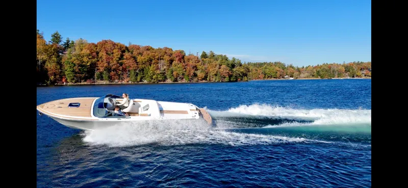 Slide: The Image of 2024 Comitti Venezia V28 speedboat cruising on a scenic lake with autumn foliage. - 14