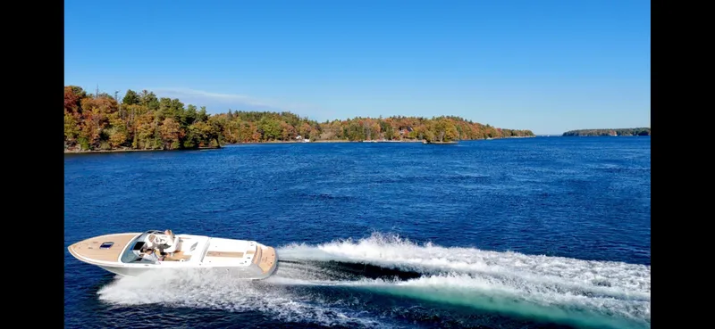 Slide: The Image of 2024 Comitti Venezia V28 speedboat cruising on a scenic lake with forested shoreline. - 15