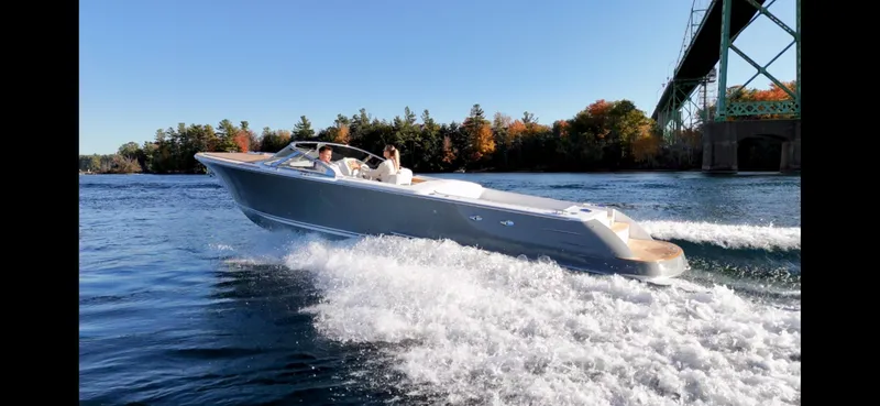 Slide: The Image of 2024 Comitti Venezia V28 speedboat cruising on a scenic lake under a bridge. - 16