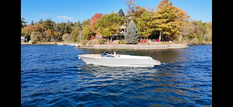 Slide: The Image of 2024 Comitti Venezia V28 boat cruising on a scenic lake with autumn foliage. - 18