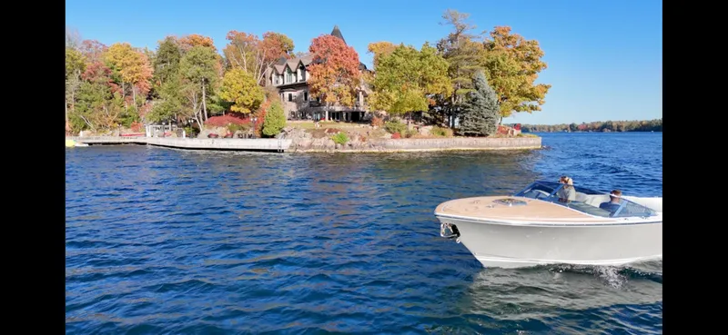 Slide: The Image of 2024 Comitti Venezia V28 boat cruising on a scenic lake with autumn foliage. - 19