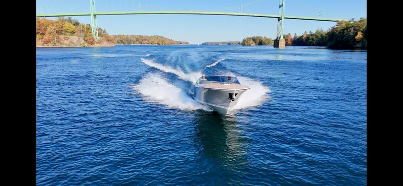Slide: The Image of 2024 Comitti Venezia V28 speedboat cruising under a bridge on a sunny day. - 21