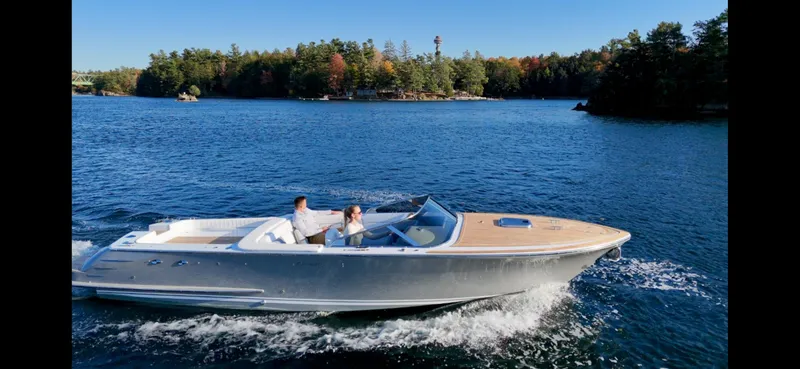 Slide: The Image of 2024 Comitti Venezia V28 cruising on a serene lake with lush forest backdrop. - 22