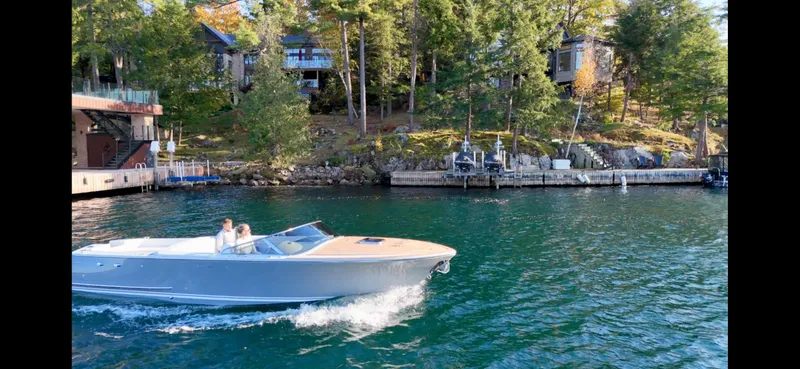 Slide: The Image of 2024 Comitti Venezia V28 cruising on a scenic lake near wooded shoreline. - 27