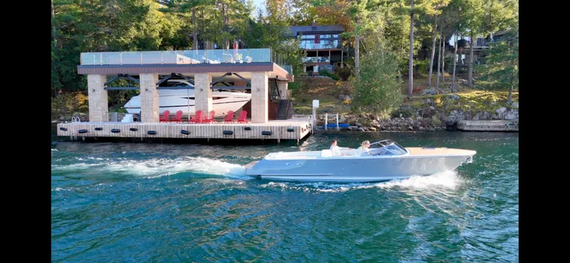 Slide: The Image of 2024 Comitti Venezia V28 cruising on a scenic lake near a modern dock. - 29