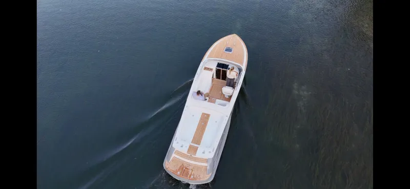 Slide: The Image of 2024 Comitti Venezia V28 luxury boat cruising on calm water, aerial view. - 4