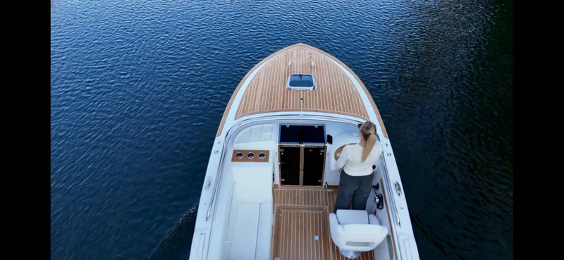 Slide: The Image of 2024 Comitti Venezia V28 boat on calm water, featuring elegant wooden deck design. - 5