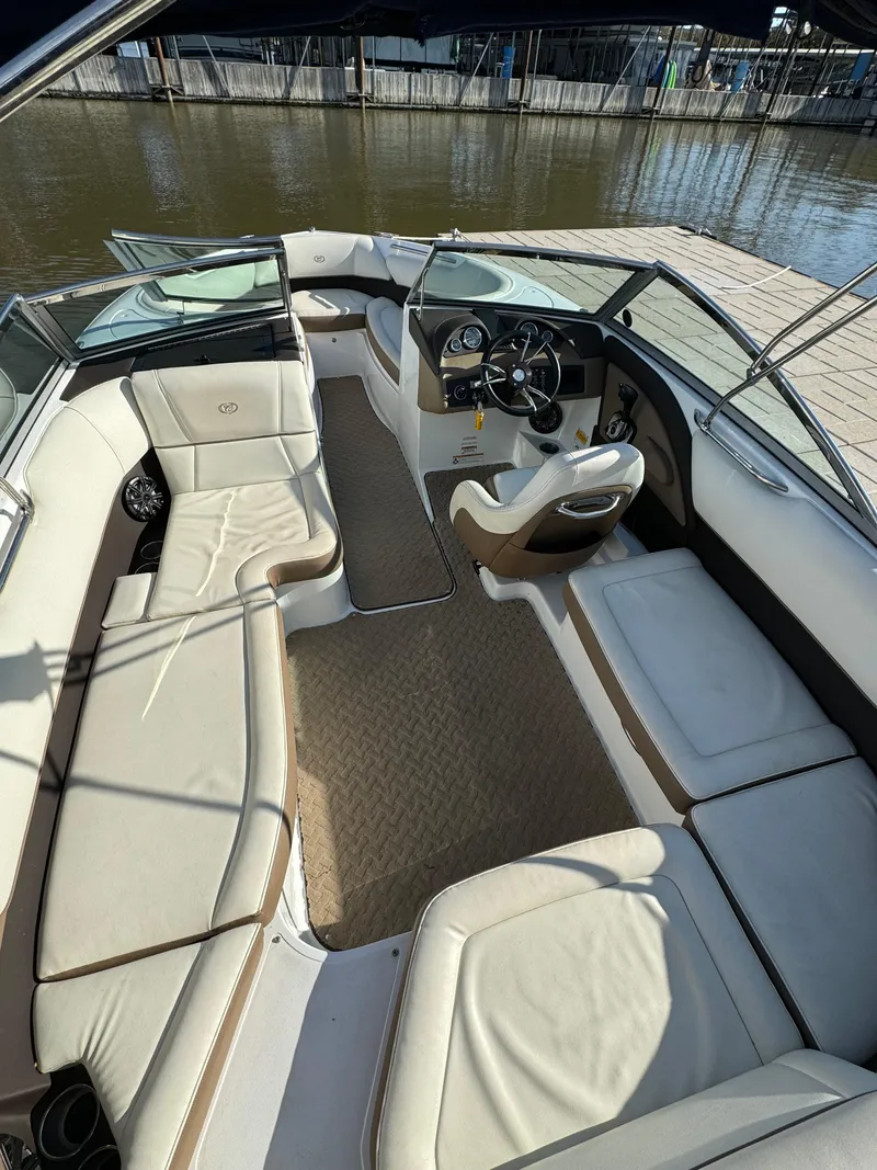 Slide: The Image of 2015 Cobalt 220 boat interior with beige seating and steering console. - 10