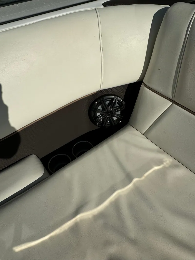 Slide: The Image of Interior of a 2015 Cobalt 220 boat with beige seating and speaker. - 12