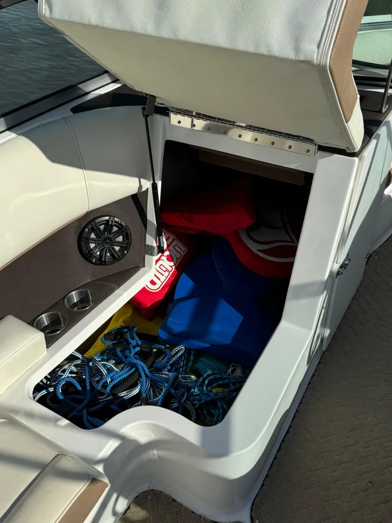 Slide: The Image of Open storage compartment in 2015 Cobalt 220 boat with ropes and life jackets. - 15