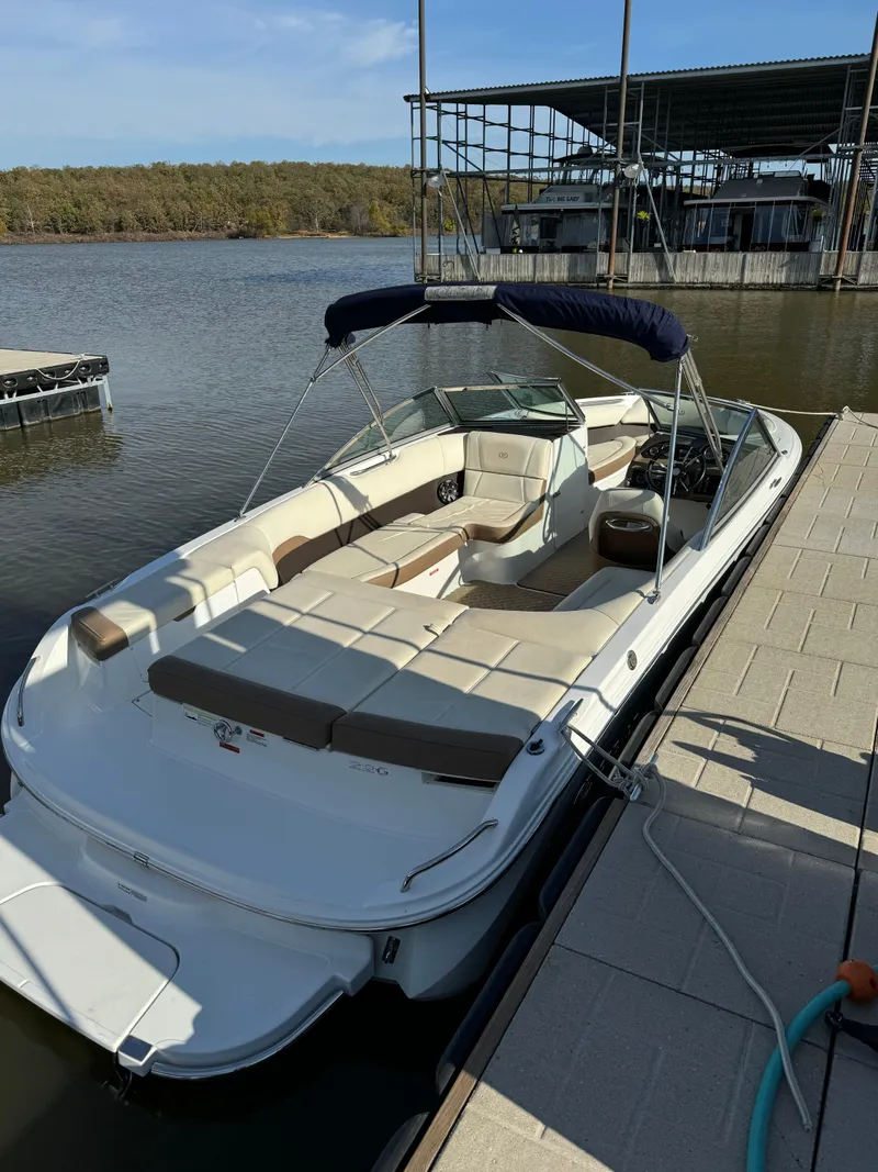 Slide: The Image of 2015 Cobalt 220 boat docked on a sunny day, featuring spacious seating and sleek design. - 7