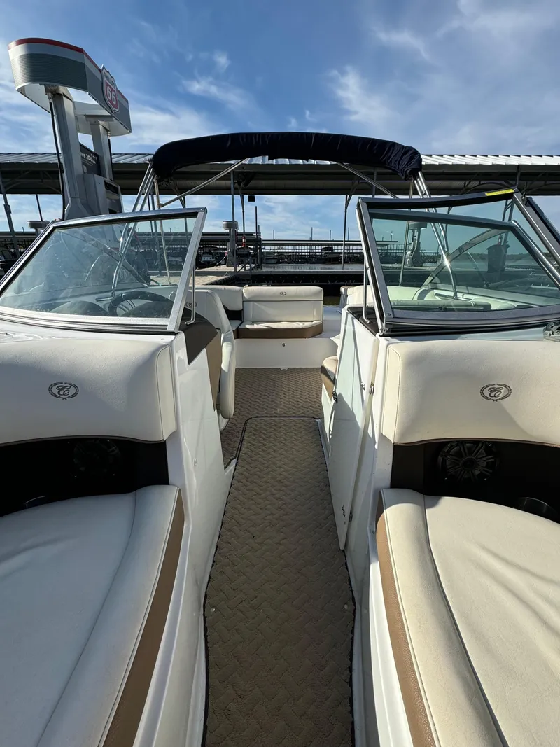 Slide: The Image of 2015 Cobalt 220 boat interior with white seating and open deck under blue sky. - 9